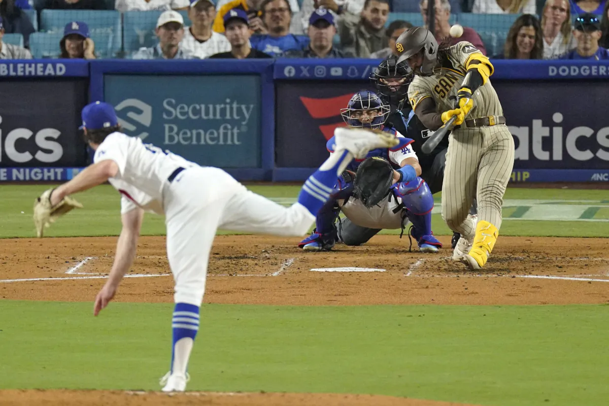 San Diego Padres' Luis Campusano, right, hits a three-run home run as Los Angeles Dodgers starting pitcher Ryan Pepiot, left, and catcher Austin Barnes, second from left, watch along with home plate umpire Ron Kulpa during the fourth inning of a baseball game in Los Angeles on Sept. 13, 2023. (Mark J. Terrill/AP Photo)