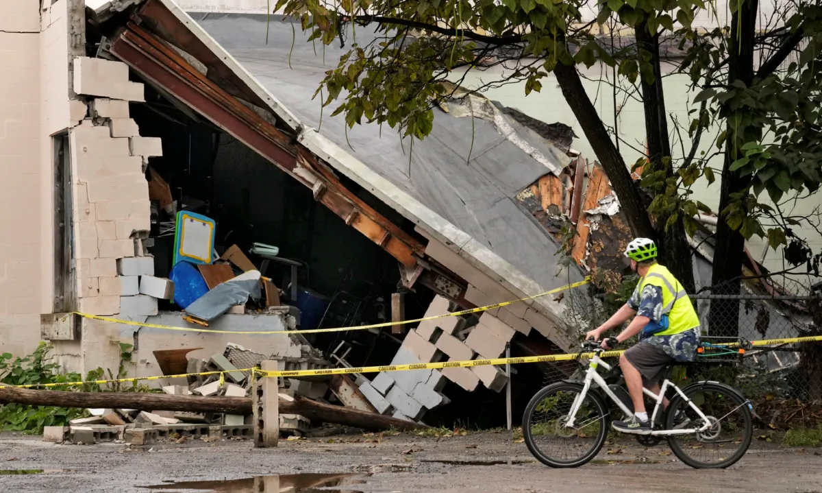 A man views damage to a building caused by recent flooding at the Hilton & Cook Marketplace in Leominster, Mass., on Sept. 13, 2023. (Robert F. Bukaty/AP Photo)