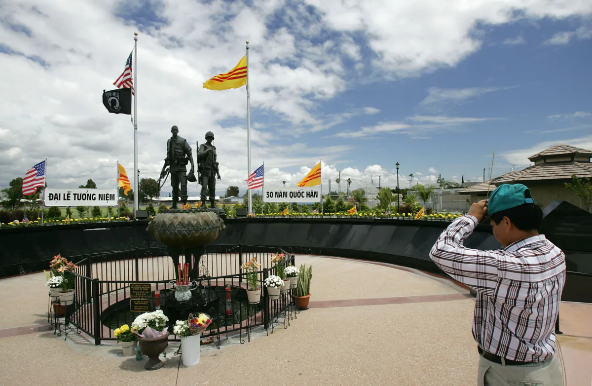 A man raises incense to his forehead as he pays his respects at the Vietnam War Memorial near the Little Saigon neighborhood in Westminster, Calif., on April 28, 2005. (David McNew/Getty Images)