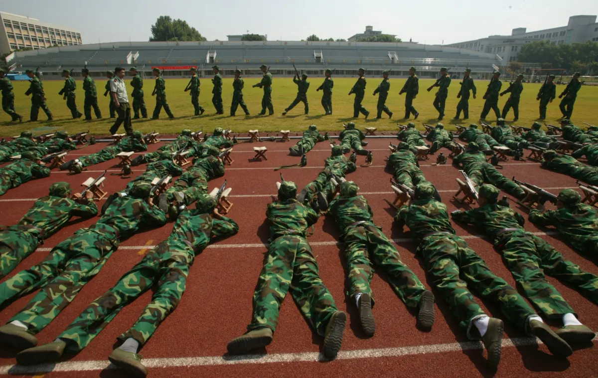 Freshmen from the Nanjing University of Science and Technology practice shooting skills during a military training session in Nanjing of Jiangsu Province, China, on Sept. 11, 2007. (China Photos/Getty Images)