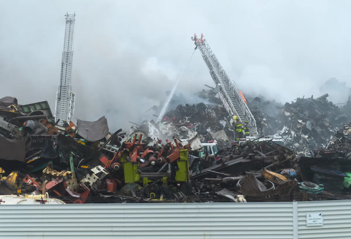 Firefighters battle a blaze at a metal recycling yard along the harbour at Saint John, New Brunswick, that has led to the closure of three schools in the area, Sept. 14, 2023. (The Canadian Press/Michael Hawkins)