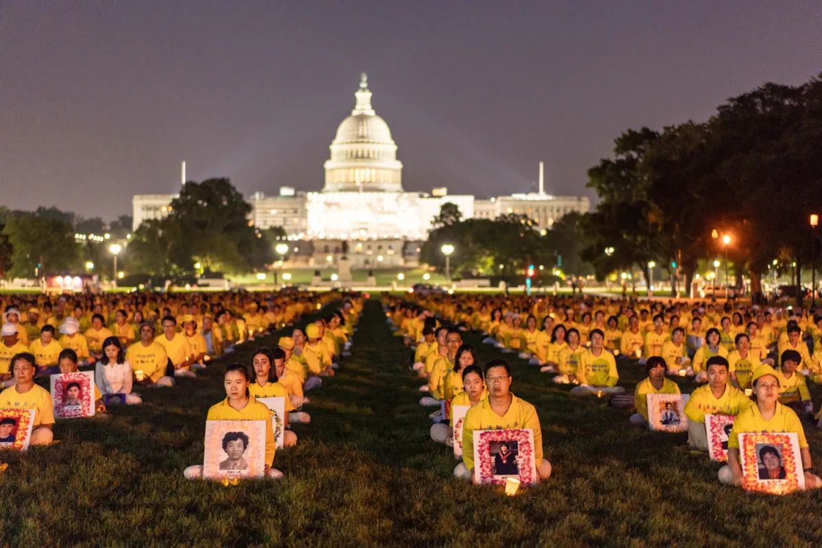 Falun Gong adherents take part in a candlelight vigil in memory of Falun Gong practitioners who passed away due to the Chinese Communist Party’s 24 years of persecution, at the National Mall in Washington on July 20, 2023. (Samira Bouaou/The Epoch Times)