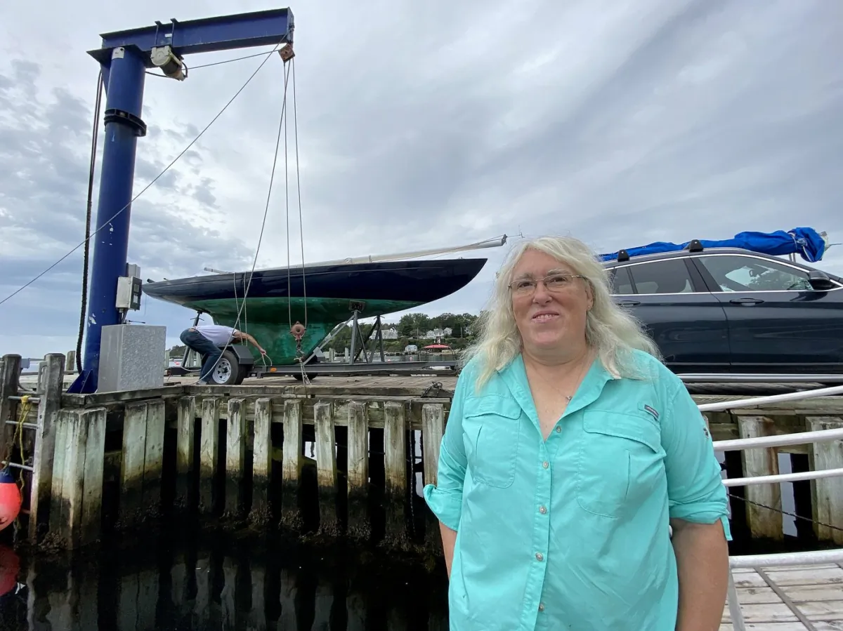 A boater removes a sailboat from the wharf in Chester N.S. in anticipation of the arrival of hurricane Lee, as Jennifer Chandler poses for a photo, on Sept. 15, 2023. (The Canadian Press/Michael MacDonald)
