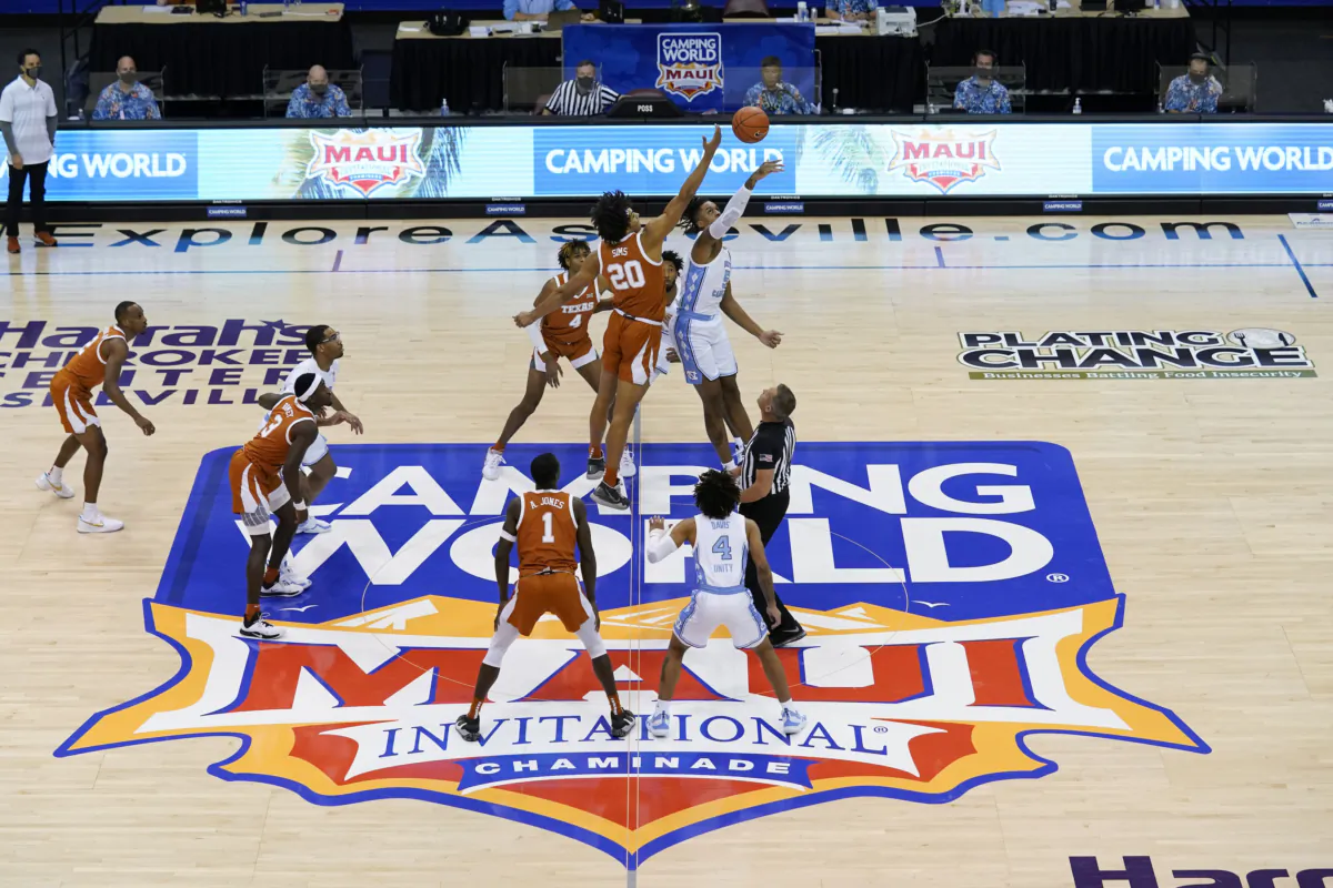 Texas forward Jericho Sims (20) and North Carolina forward Armando Bacot (5) tip off for the start of an NCAA college basketball game for the championship of the Maui Invitational, in Asheville, N.C., on Dec. 2, 2020, (Kathy Kmonicek/AP Photo)