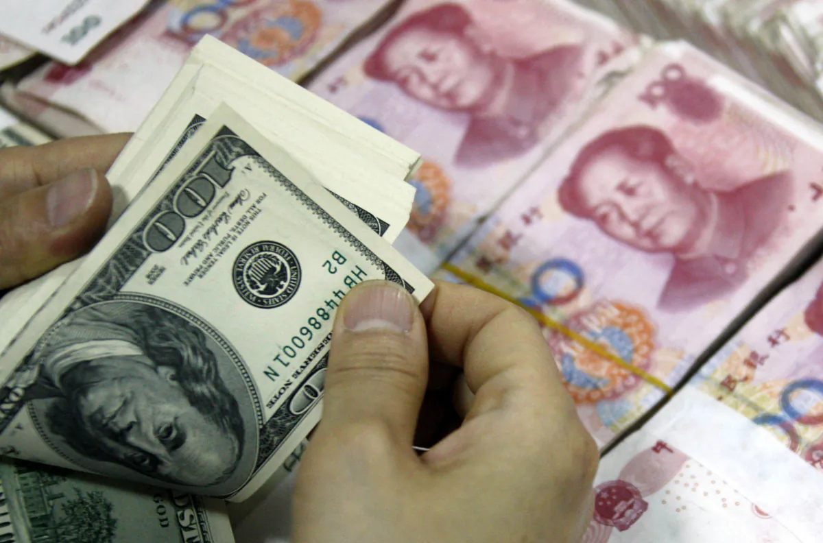 U.S. dollar notes are counted next to stacks of 100 yuan (RMB) bank notes at a bank in Huaibei, in eastern China's Anhui Province, on Sept. 24, 2013.(STR/AFP via Getty Images)