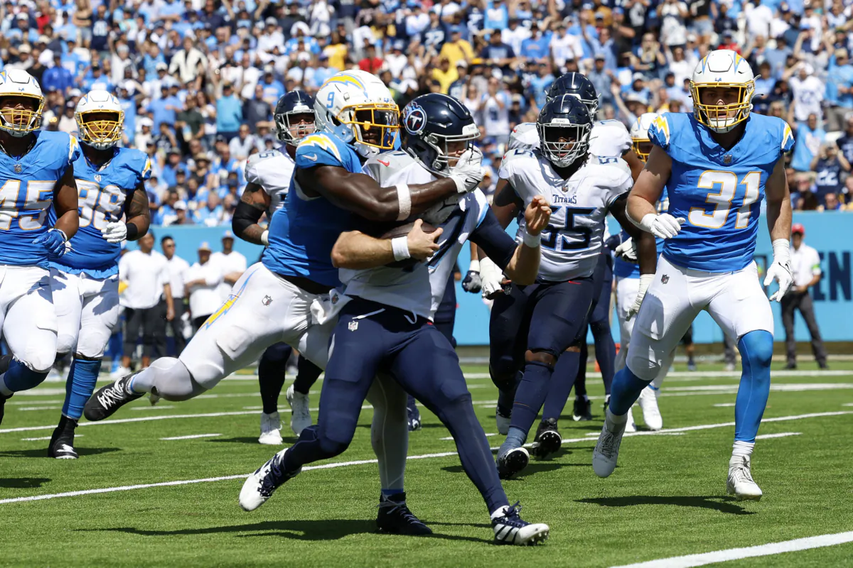 Kenneth Murray Jr. (9) of the Los Angeles Chargers attempts to tackle Ryan Tannehill (17) of the Tennessee Titans as Tannehill rushes for a touchdown  during the third quarter at Nissan Stadium in Nashville on Sept. 17, 2023. (Wesley Hitt/Getty Images)