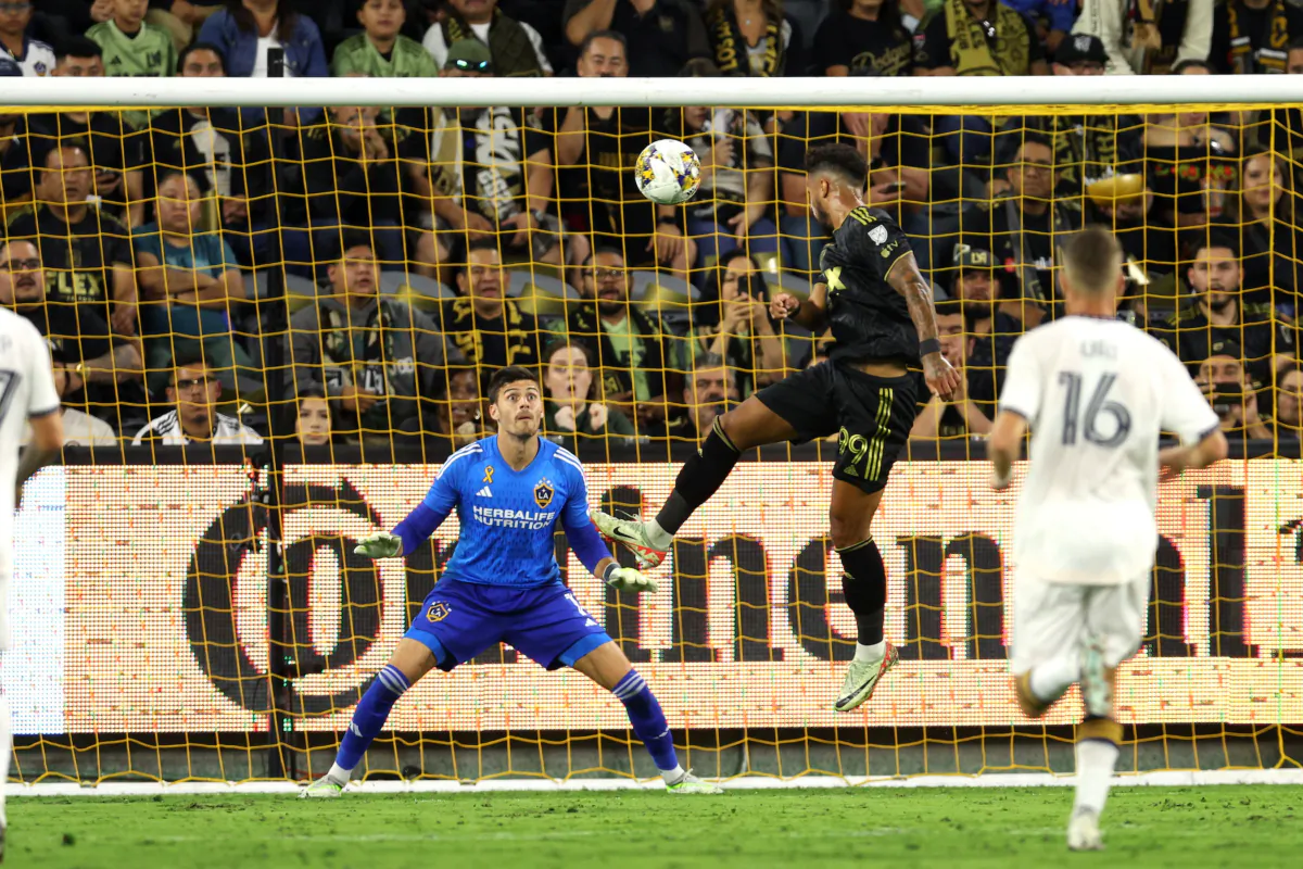 Los Angeles FC forward Denis Bouanga (99) scores a goal past Los Angeles Galaxy goalkeeper Jonathan Bond (1) off a pass by Los Angeles Galaxy forward Michael Barrios (12) in the first half at BMO Stadium in Los Angeles on Sept. 16, 2023. (Courtesy of LAFC via The Epoch Times).