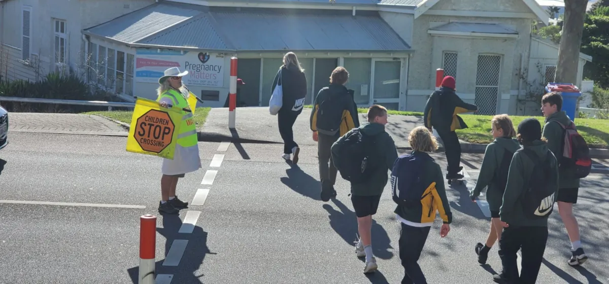 School kids cross a road while a traffic warden stops cars in Albany, Western Australia, on Sept. 18, 2023. (Susan Mortimer/The Epoch Times)