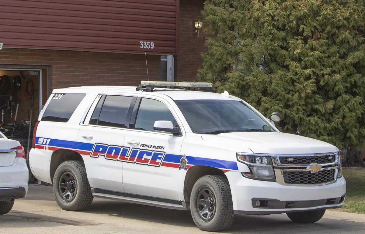 A Prince Albert Police car is seen parked at a property subject to investigation, in Prince Albert, Sask., on May 13, 2021. (The Canadian Press/Kayle Neis)