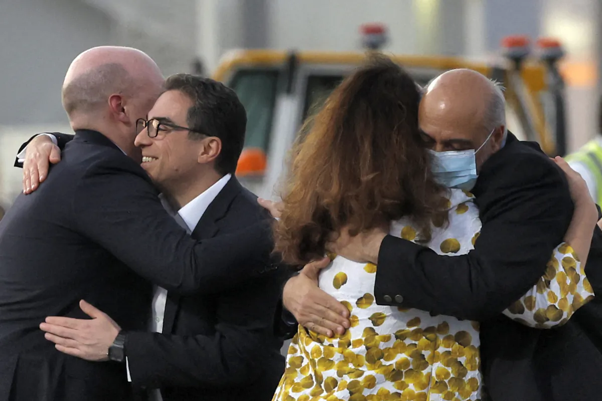 U.S. citizens Siamak Namazi (2nd-L) and Morad Tahbaz (R) are welcomed by people upon disembarking from a Qatari jet upon their arrival at the Doha International Airport in Doha, Qatar, on Sept. 18, 2023. (Karim Jaafar/AFP via Getty Images)