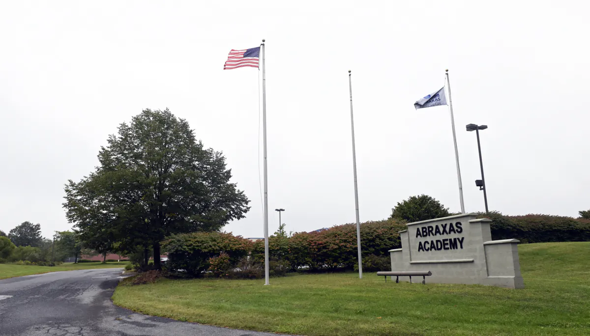 Flags flutter in the wind near an entrance to the Abraxas Academy in Morgantown, Pa., on Sept. 18 2023. (Bill Uhrich/Reading Eagle via AP)