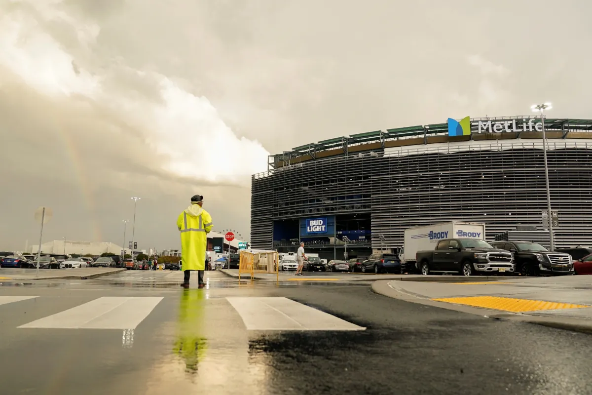 A parking attendant views a rainbow outside Met Life stadium before an NFL football game between the New York Jets and the Buffalo Bills in East Rutherford, N.J. on Sept. 11, 2023. (Seth Wenig/AP Photo)