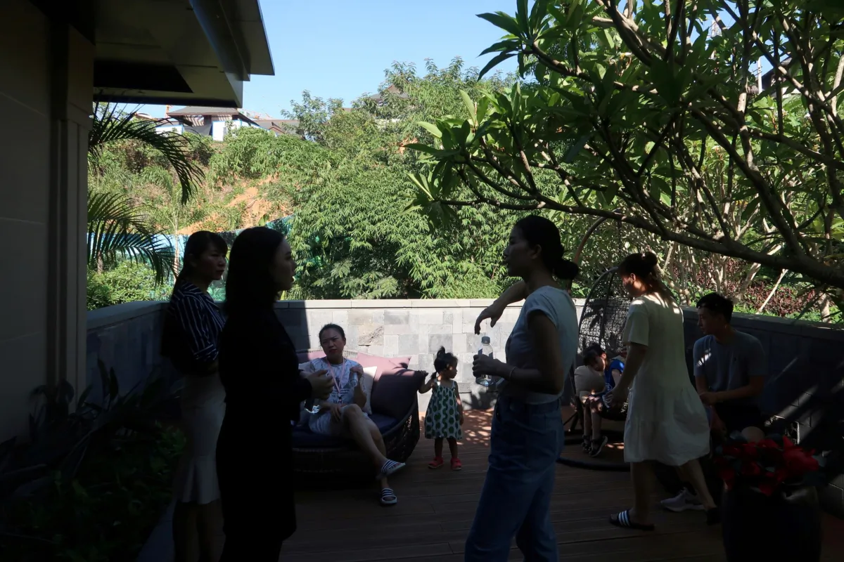 People on a property tour talk outside of a show flat at a residential property developed by Sunac China Holdings in Xishuangbanna Dai Autonomous Prefecture, Yunnan Province, China, on June 22, 2019. (Lusha Zhang/Reuters)