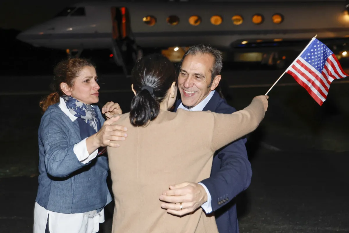 Family members embrace freed American Emad Shargi after he and four fellow detainees were released in a prisoner swap deal between U.S and Iran, as he arrives at Davison Army Airfield at Fort Belvoir, Va., on Sept. 19, 2023. (Jonathan Ernst/Pool via AP)