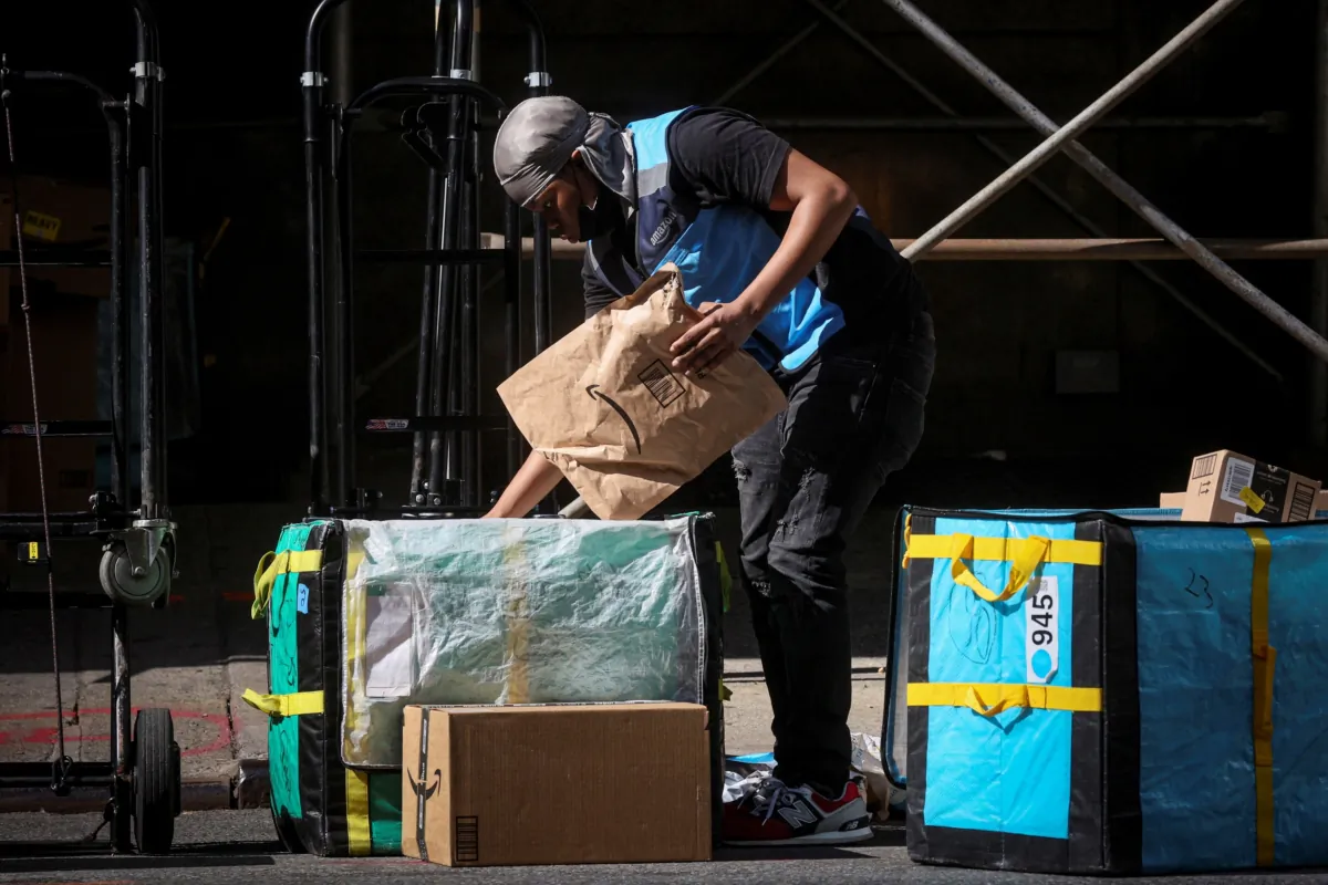 An Amazon delivery worker sorts packages out for delivery during Amazon's two-day "Prime Early Access Sale" shopping event for Amazon members in the financial district of New York on Oct. 11, 2022. (Brendan McDermid/Reuters)