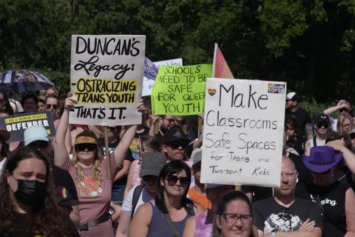 People protest at the Legislative Building in Regina on Sept. 2, 2023, against a recent government policy that says schools in Saskatchewan must seek parent or guardian permission when changing the preferred name and pronouns used by students under the age of 16. (The Canadian Press/Michael Bell)