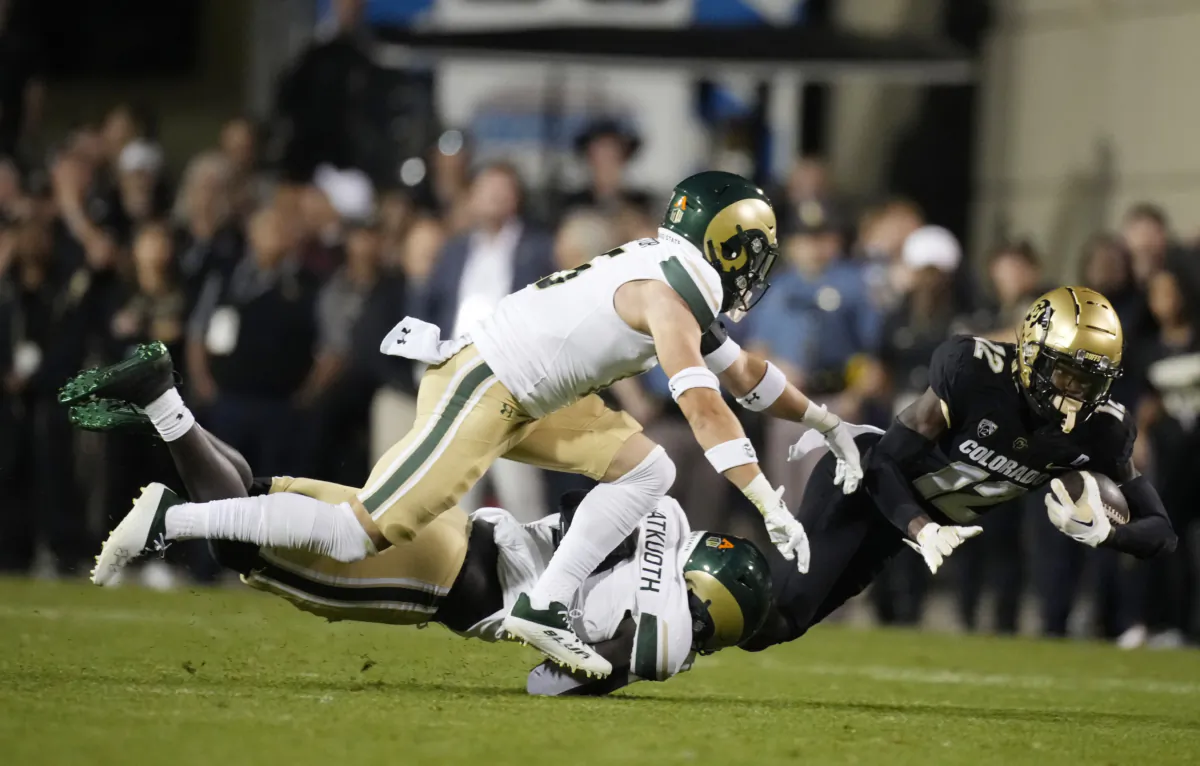 Colorado cornerback Travis Hunter (12) is dragged down after a short gain by Colorado State defensive back Henry Blackburn, back left, and defensive back Ayden Hector during the first half of an NCAA college football game in Boulder, Colo. on Sept. 16, 2023. (David Zalubowski/AP Photo)