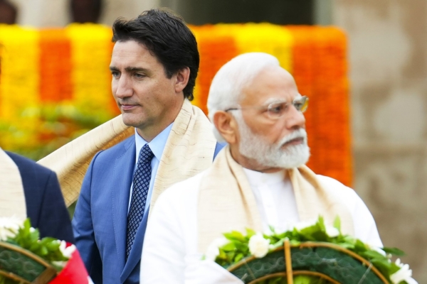 Prime Minister Justin Trudeau walks past Indian Prime Minister Narendra Modi as they take part in a wreath-laying ceremony at Raj Ghat, Mahatma Gandhi's cremation site, during the G20 Summit in New Delhi, on Sept. 10, 2023. (The Canadian Press via AP/Sean Kilpatrick)