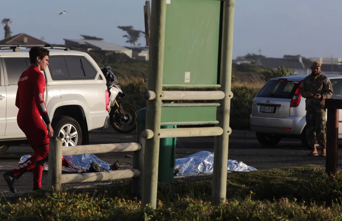The bodies of two South Africa Navy personal lay covered after being recovered from the sea at Kommetjie, ear Cape own, South Africa, on Sept. 20, 2023. (Halden Krog/AP Photo)