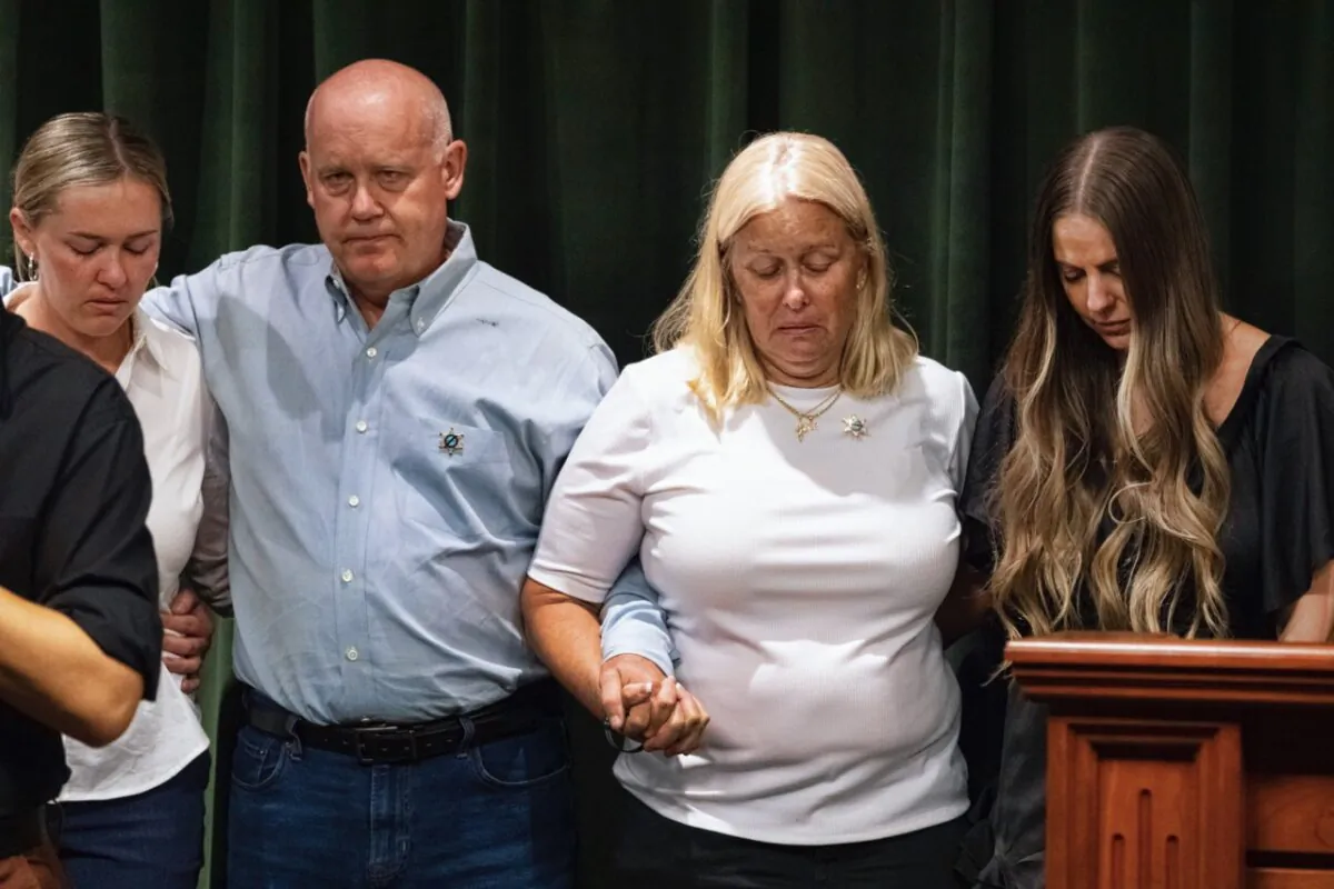 Sheriff's deputy Ryan Clinkunbroomer's parents clasp arms with his fiancee Brittany Lindsey (R) during a news conference at the Hall of Justice in downtown Los Angeles on Sept. 20, 2023. (AP Photo/Richard Vogel)
