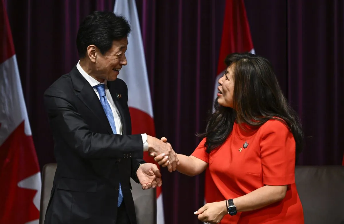 Japan's Minister of Economy, Trade and Industry Nishimura Yasutoshi (L) shakes hands with Canada's Minister of Export Promotion, International Trade and Economic Development Mary Ng, during a signing ceremony in Ottawa, on Sept. 21, 2023. (The Canadian Press/Justin Tang)
