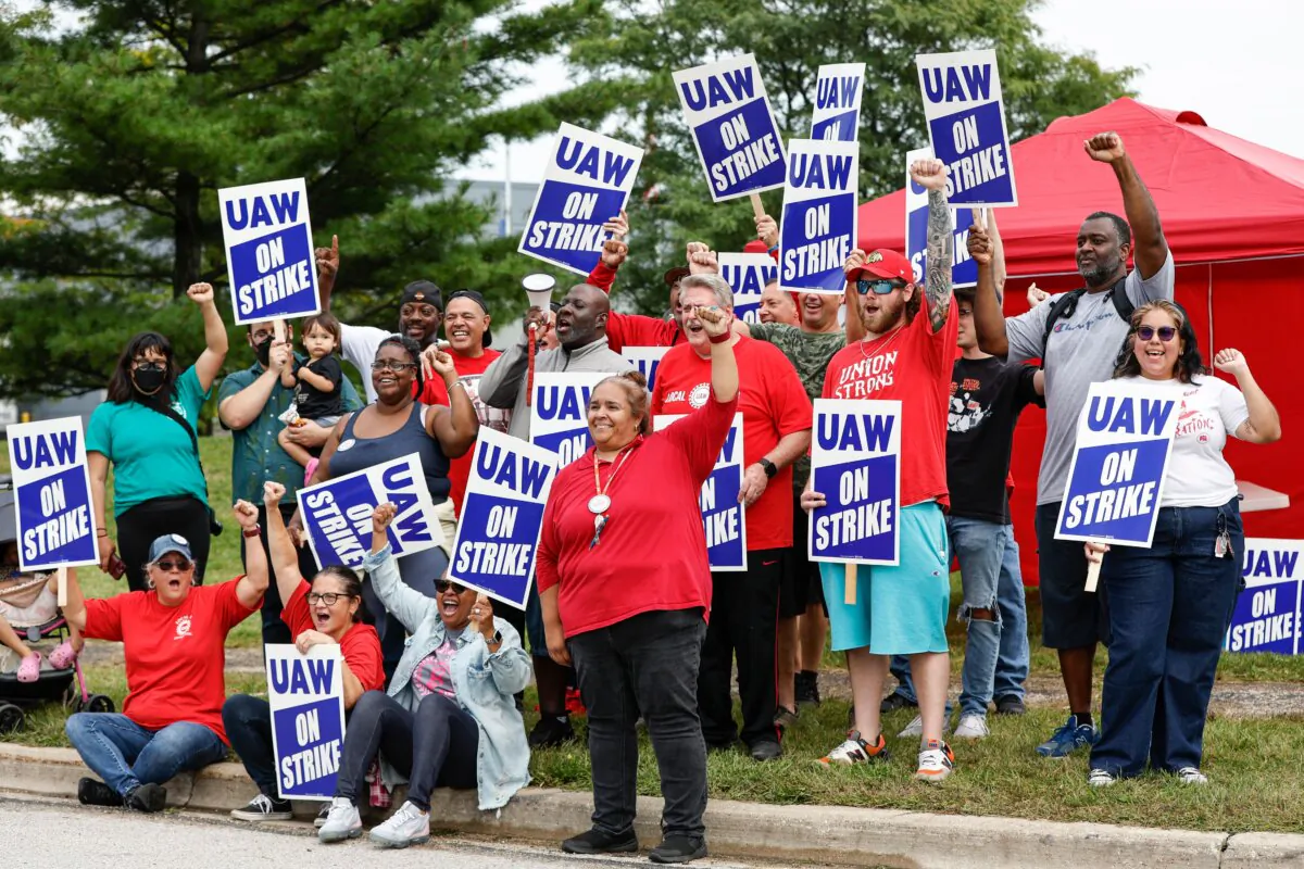 UAW  members and workers at the Mopar Parts Center Line, a Stellantis Parts Distribution Center in Center Line, Mich., hold signs outside the facility after walking off their jobs at noon on Sept. 22, 2023. (Kamil Krzaczynski/AFP via Getty Images)