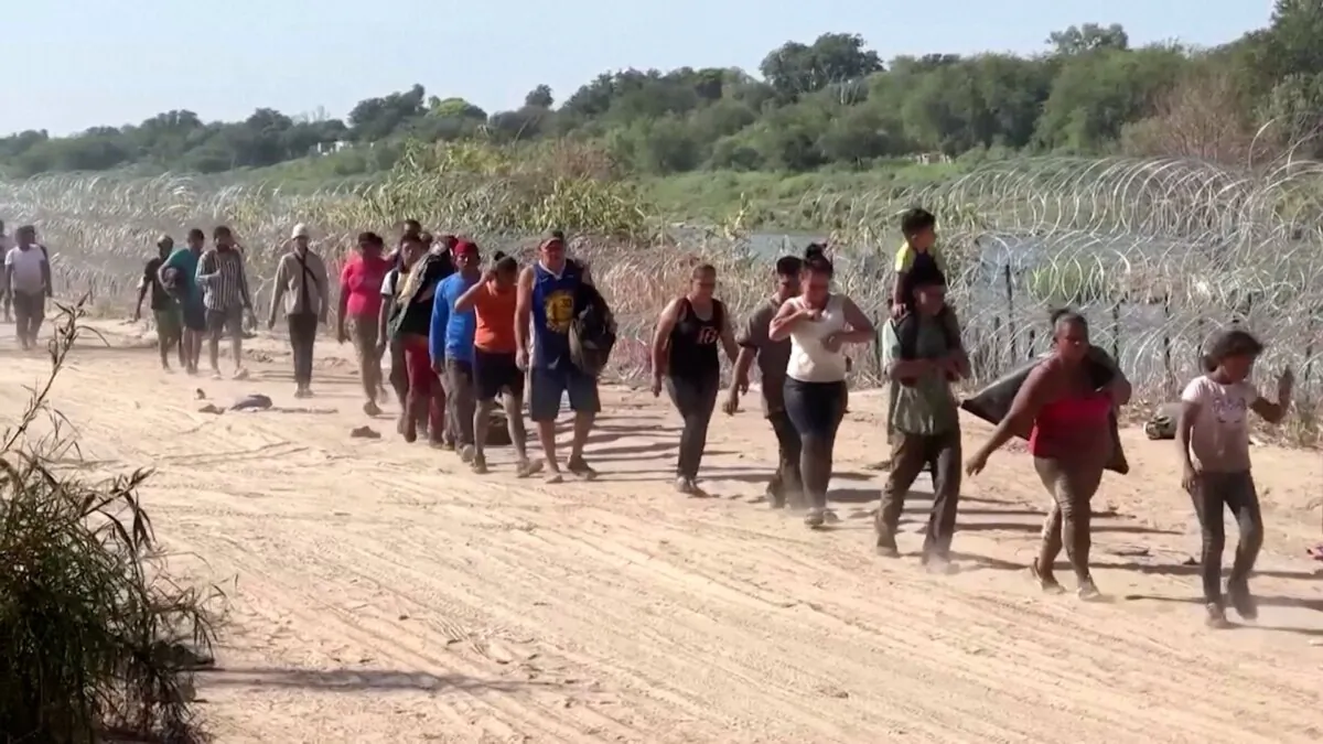 A group of illegal immigrants walk on a dirt road in Eagle Pass, Texas, on Sept. 22, 2023. (Reuters/Screenshot via NTD)
