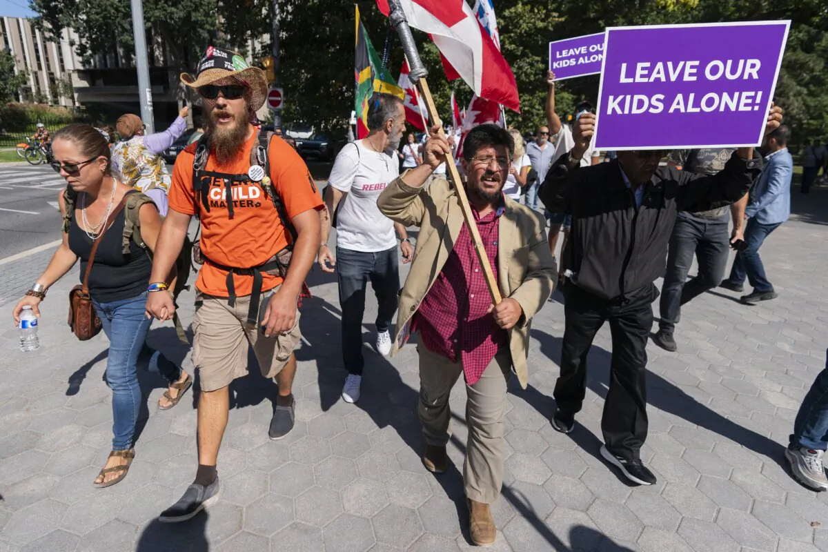 Participants march near the grounds of Queen's Park in Toronto during the cross-Canada "1MillionMarch4Children" protest on Sept. 20, 2023. (The Canadian Press/Spencer Colby)