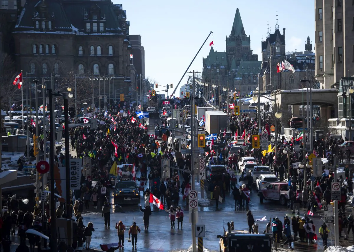 People and vehicles fill Wellington Street near Parliament Hill on the first day of the Freedom Convoy protest against COVID-19 restrictions, in Ottawa on Jan. 29, 2022. (The Canadian Press/Justin Tang)