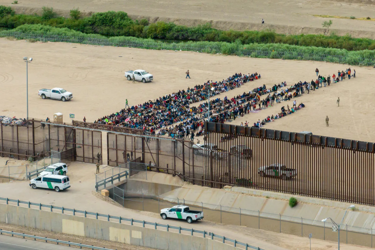 Migrants are grouped together while waiting to be processed on the Ciudad Juarez side of the border, in El Paso, Texas, on Sept. 21, 2023. (Brandon Bell/Getty Images)