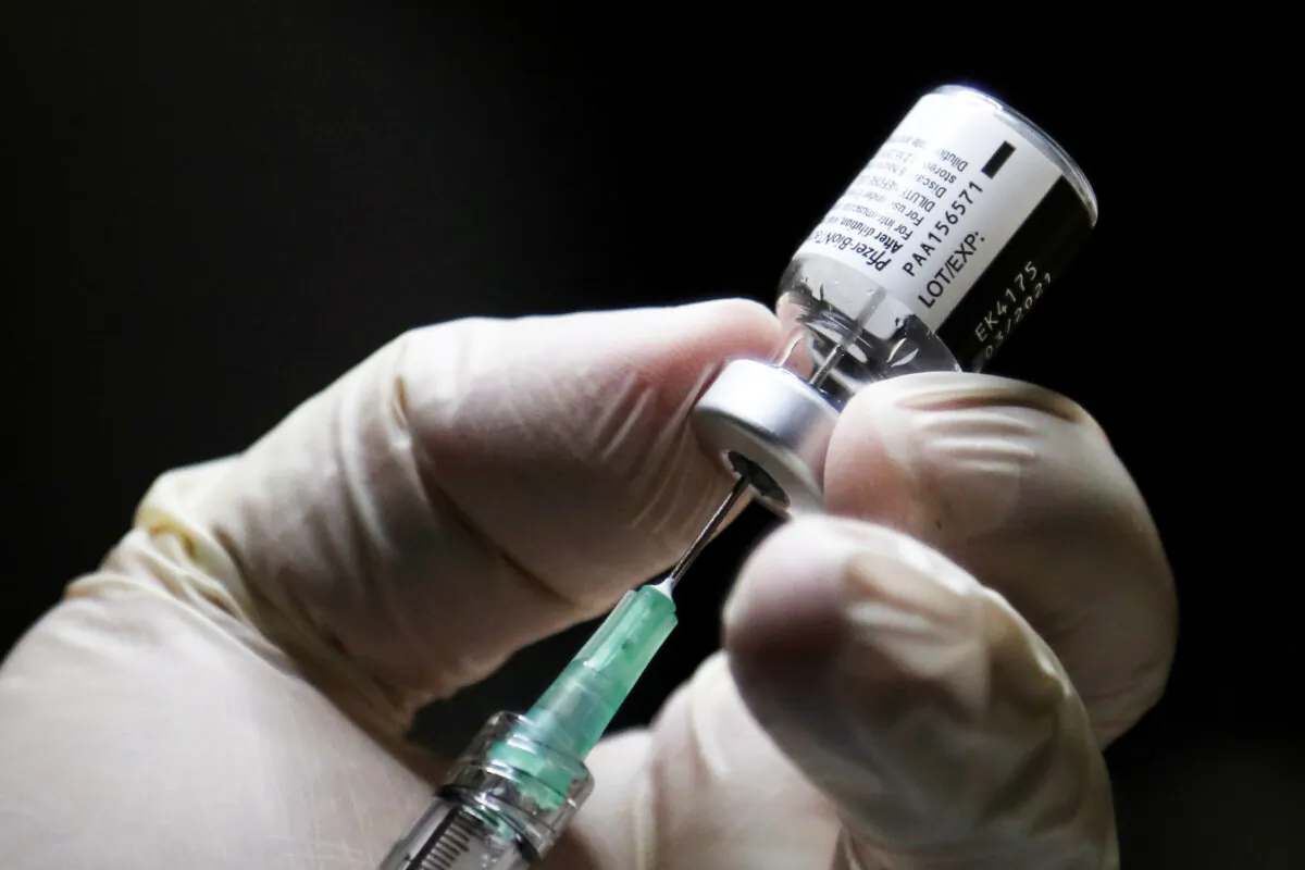 A health-care worker prepares a dose Pfizer/BioNTech COVID-19 vaccine at the Michener Institute in Toronto on Dec.14, 2020. (Carlos Osorio/AFP via Getty Images)