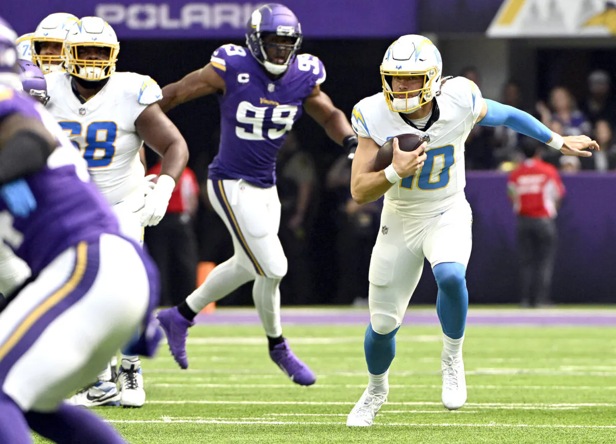 Justin Herbert (10) of the Los Angeles Chargers scrambles during the first quarter against the Minnesota Vikings at U.S. Bank Stadium in Minneapolis on Sept. 24, 2023. (Stephen Maturen/Getty Images)