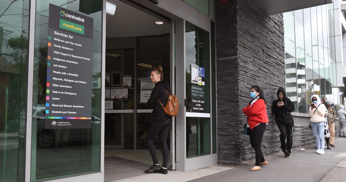 People queue outside an Australian government welfare centre, Centrelink, in Melbourne, Australia, on March 23, 2020. (William West/AFP via Getty Images)