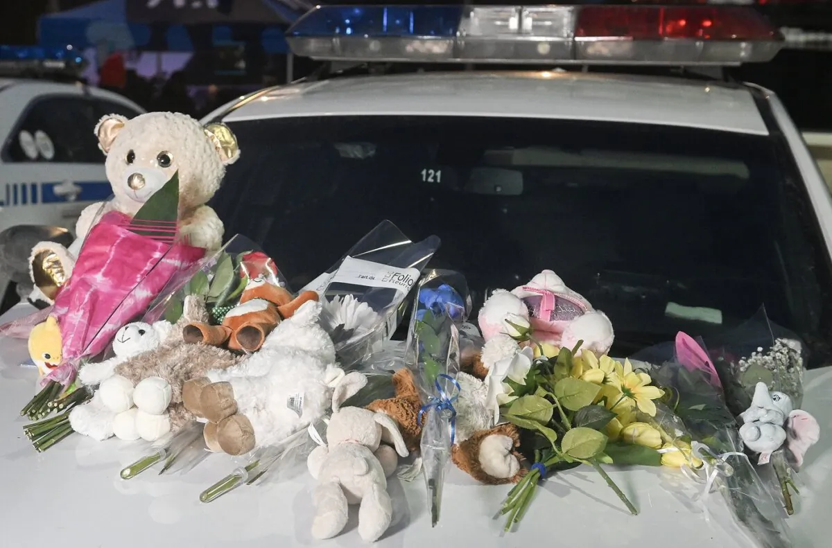 A makeshift memorial is shown on a police car in Laval, Que, on Feb. 8, 2023, near the scene where a city bus crashed into a daycare centre leaving two children dead. (The Canadian Press/Graham Hughes)