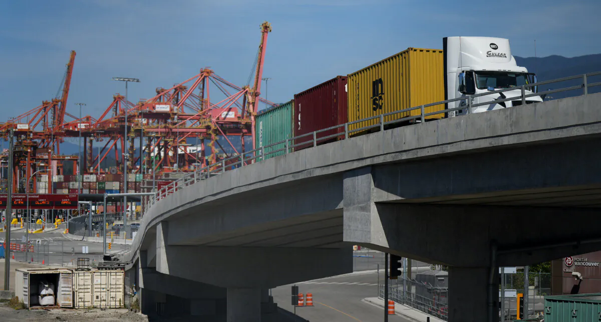 A transport truck carries cargo containers from the Centerm Container Terminal at port in Vancouver on July 14, 2023. (The Canadian Press/Darryl Dyck)