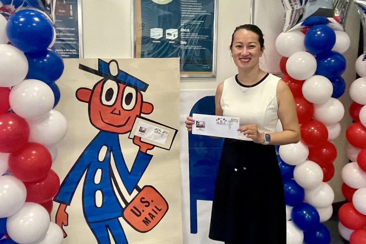 Irvine Post Master Lam Le displays a limited-edition postmark at Irvine Harvest Station Post Office in Irvine, Calif., on Sept. 26, 2023. (Carol Cassis/The Epoch Times)