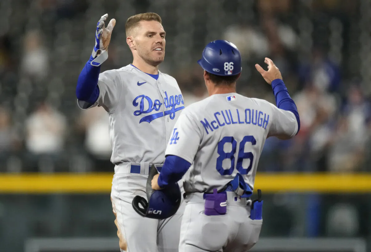 Los Angeles Dodgers first base coach Clayton McCullough, right, congratulates Freddie Freeman after his double off Colorado Rockies relief pitcher Victor Vodnik in the ninth inning of the second game of a baseball doubleheader in Denver on Sept. 26, 2023. (David Zalubowski/AP Photo)
