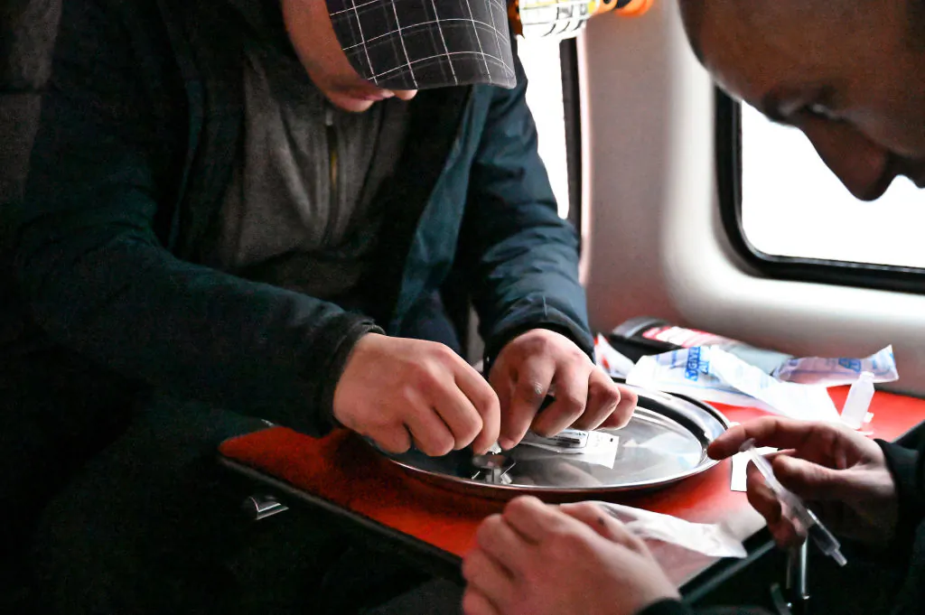 Drug users prepare cocaine before injecting, inside of a safe consumption van in Glasgow, Scotland, on Nov. 6, 2020. (Photo by Jeff J Mitchell/Getty Images)