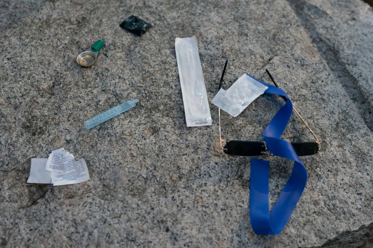 Items are seen on the ground as paramedics from B.C. Ambulance respond to a drug overdose in downtown Vancouver on June 23, 2021. (The Canadian Press/Jonathan Hayward)