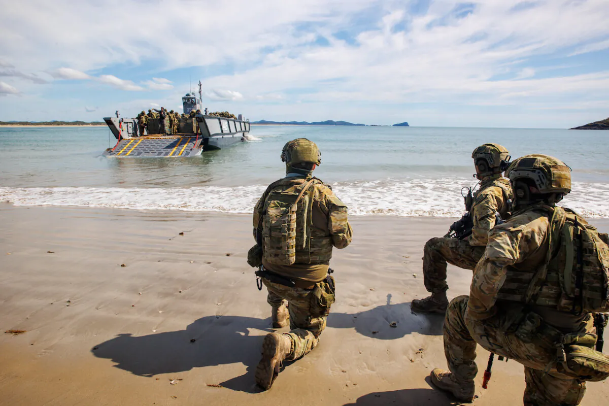 Australian Army soldiers from 10th Force Support Battalion's Amphibious Beaching Team await the arrival of troops on an Lighter Landing Craft during Exercise Trident 2022 near Shoalwater Bay Training Area, Queensland. (Courtesy of the Australian Defence Force)