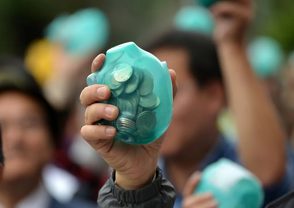 A person holds up a piggy bank at a party fundraiser in Taipei on Dec. 20, 2015. (Sam Yeh/AFP via Getty Images)