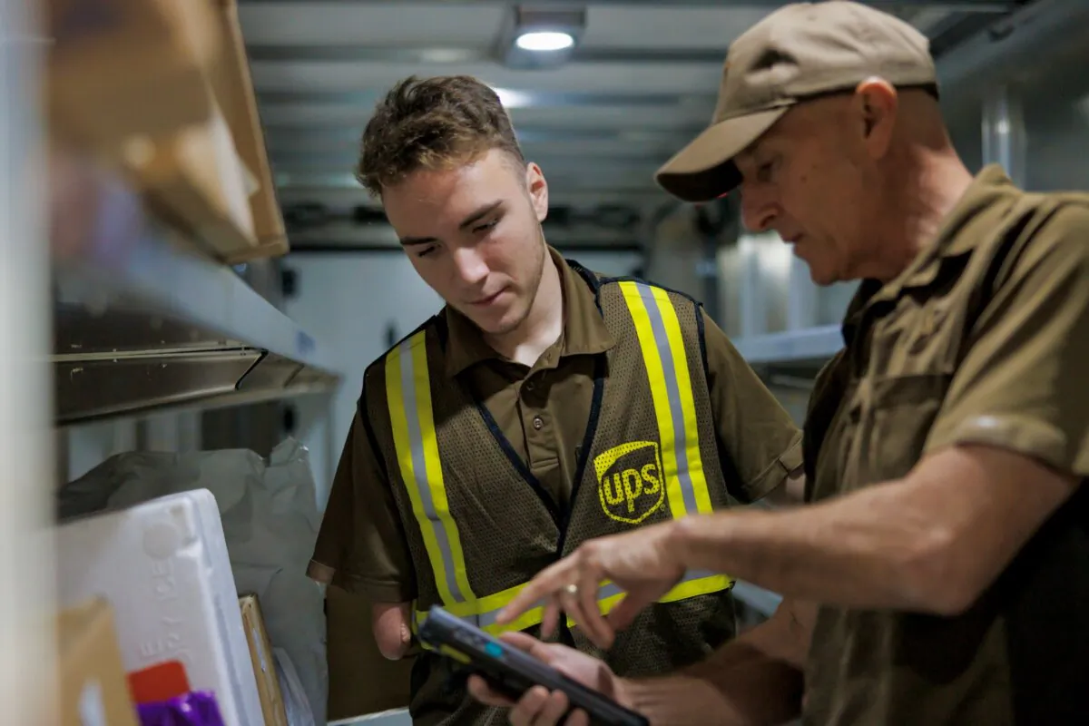 File photo of a UPS driver helper working alongside a driver delivering packages shipped by the company. (Courtesy of UPS)