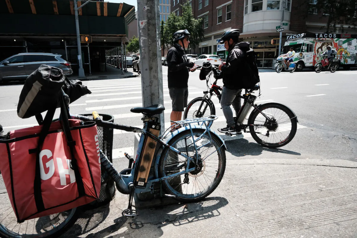 A person speaks to a delivery worker outside of restaurant that uses app deliveries in New York City, on July 7, 2023. (Spencer Platt/Getty Images)