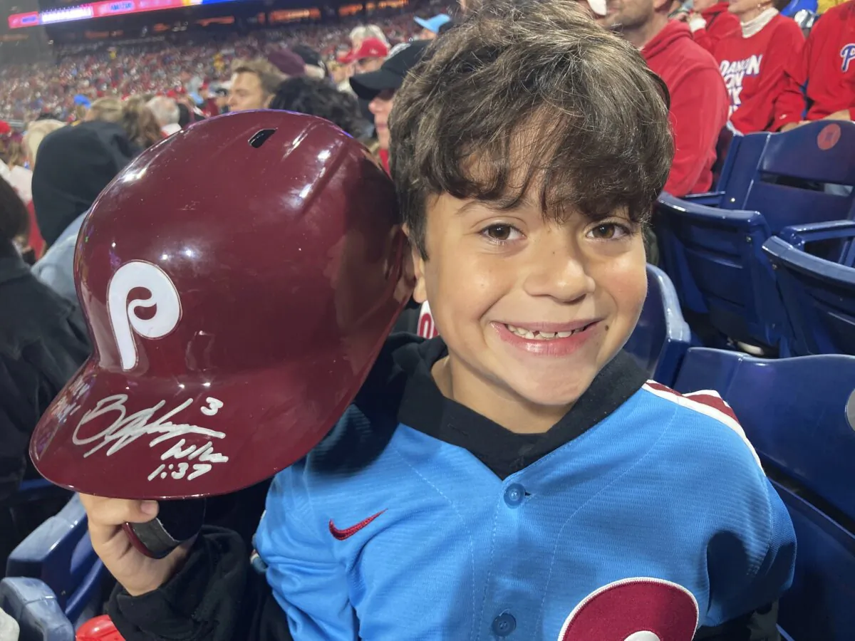 Hayden Dorfman, 10, of Voorhees, N.J., holds up Philadelphia Phillies slugger Bryce Harper’s autographed helmet during a baseball game against the Pittsburgh Pirates in Philadelphia on Sept. 28, 2023. (Daniel Gelston/AP Photo)