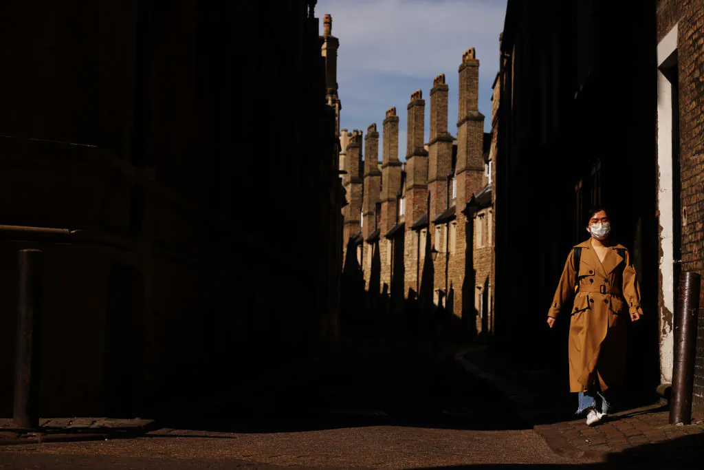 A young woman walks through the streets of Cambridge, England, on March 30, 2021. (Dan Kitwood/Getty Images)