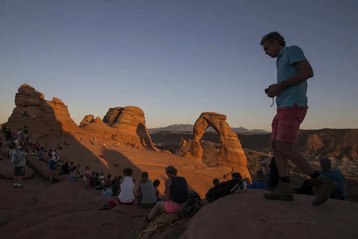 People gather to watch the sunset at Delicate Arch in Arches National Park near Moab, Utah, on Sept. 8, 2016. (Spenser Heaps/The Deseret News via AP)