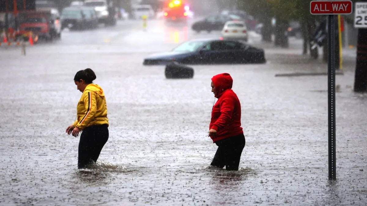Residents walk through floodwaters during a heavy rain storm in the New York City suburb of Mamaroneck in Westchester County, N.Y., on Sept. 29, 2023. (Mike Segar/Reuters)