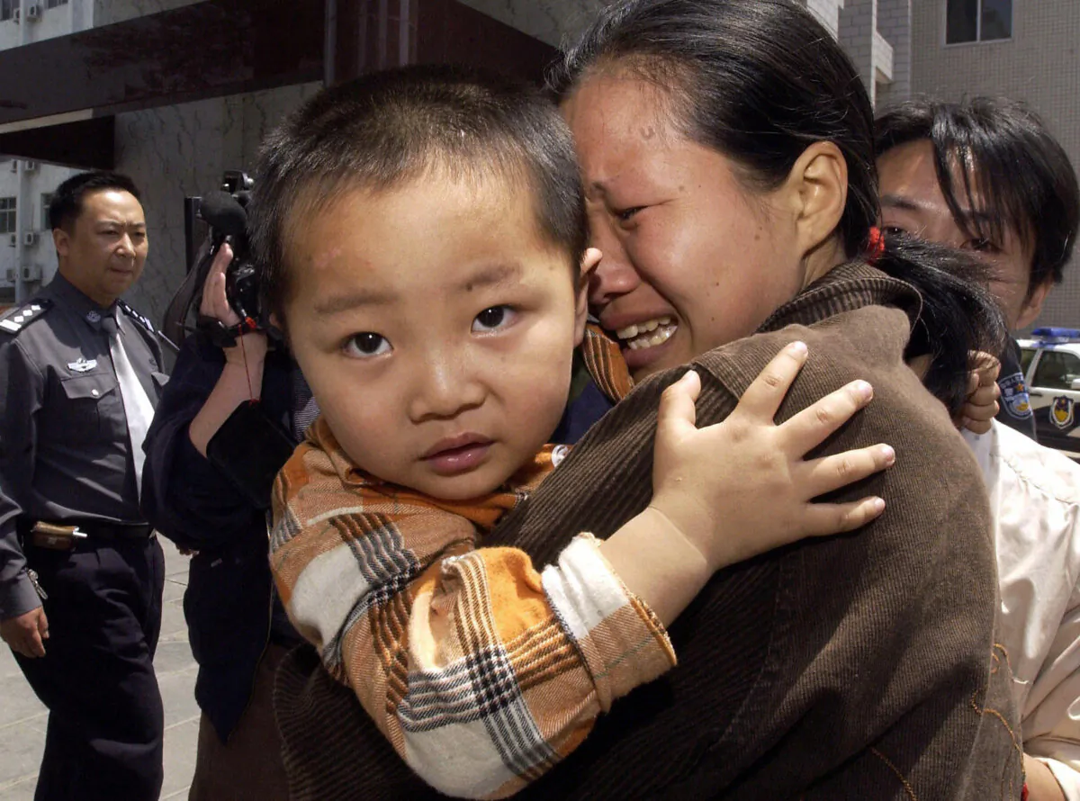 A woman cries as she is reunited with her son, one of the children rescued from a group of human traffickers in Zhengzhou, central China's Henan province 06 May 2005. (STR/AFP via Getty Images)