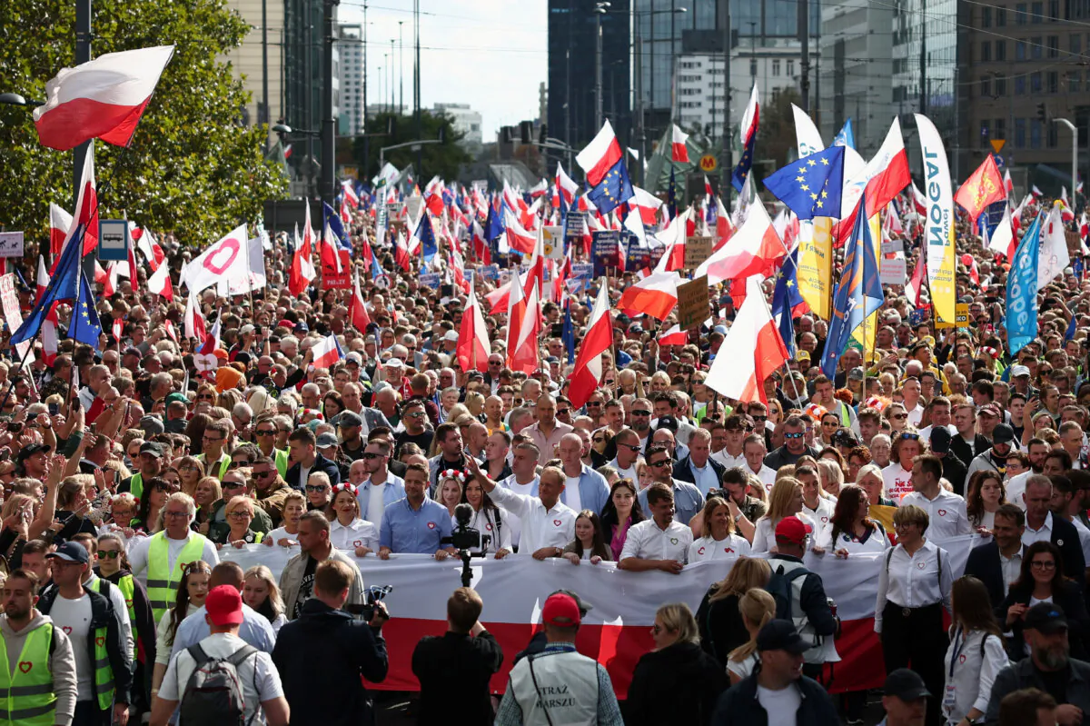 Donald Tusk, the leader of the largest opposition grouping Civic Coalition (KO), and Rafal Trzaskowski, mayor of Warsaw, march in front of the Polish national flag during the "Marsz Miliona Serc" rally in Warsaw on Oct. 1, 2023. (Kacper Pempel/Reuters)