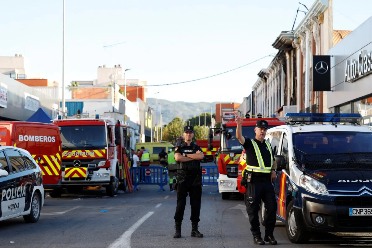 Police officers stand outside after adjoining nightclubs caught fire in Murcia, Spain, on Oct. 1, 2023. (Eva Manez/Reuters)